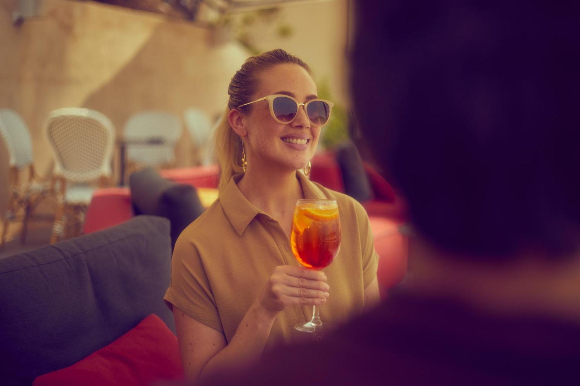Secrets Mallorca Villamil Resort & Spa - Adults Only Peguera Kültér fotó A woman drinking an Aperol Spritz